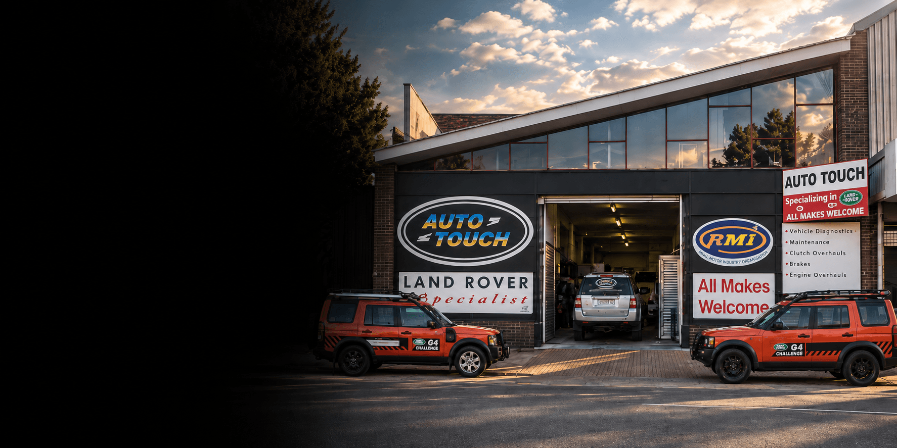 Auto Touch workshop at 53 Church Street, Krugersdorp — Land Rover Discoverys parked outside the service bays at dusk